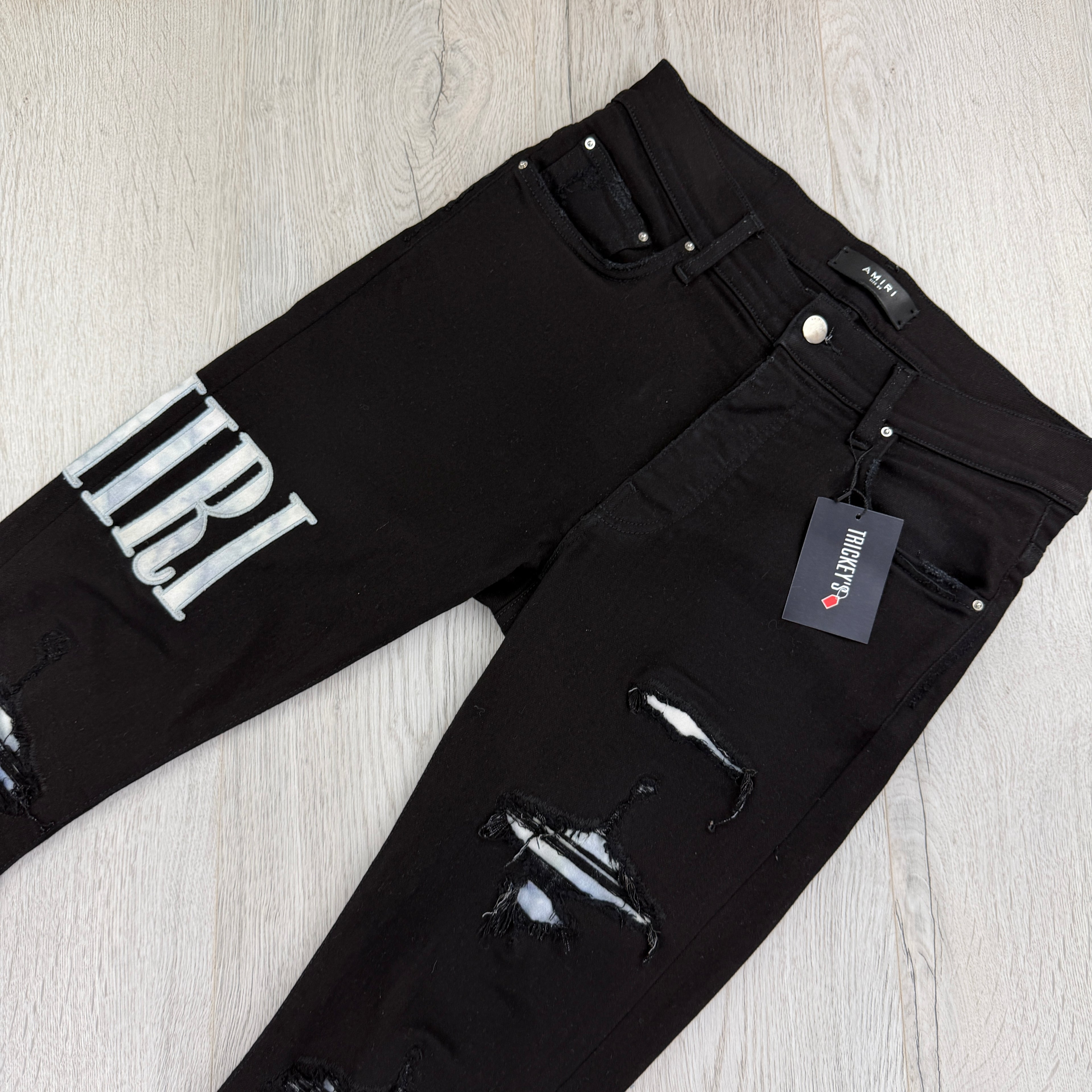 Amiri MX1 Men’s Black Distressed Jeans With Blue Side Logo